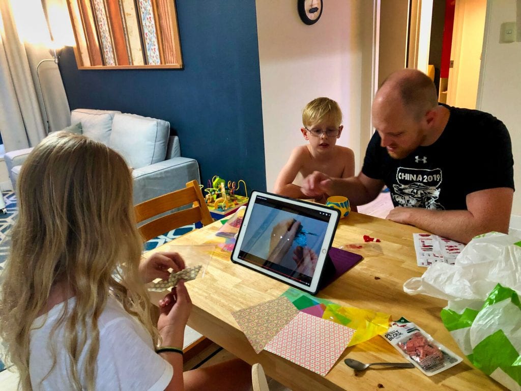 The two oldest working on a homeschooling project with Chris 