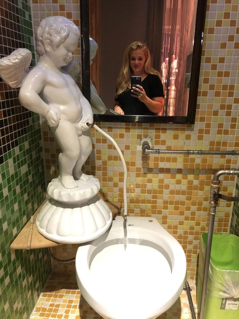Mirror selfie with a funny bathroom statue of an angel peeing 