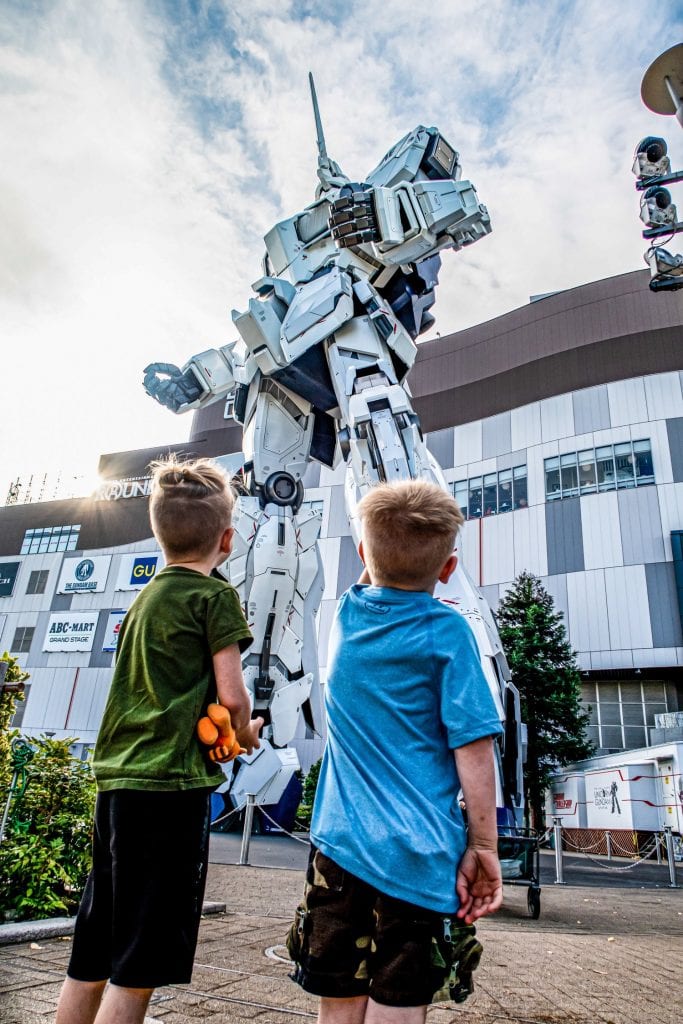 traveling family: boy staring at a hug transformer statue 