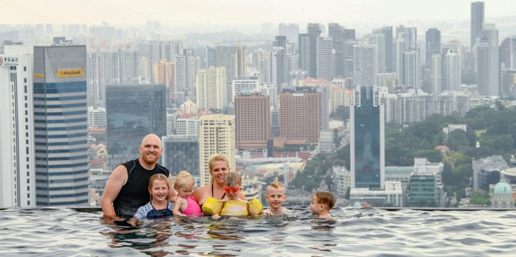 Family photo in Singapore in an infinity pool with the city view